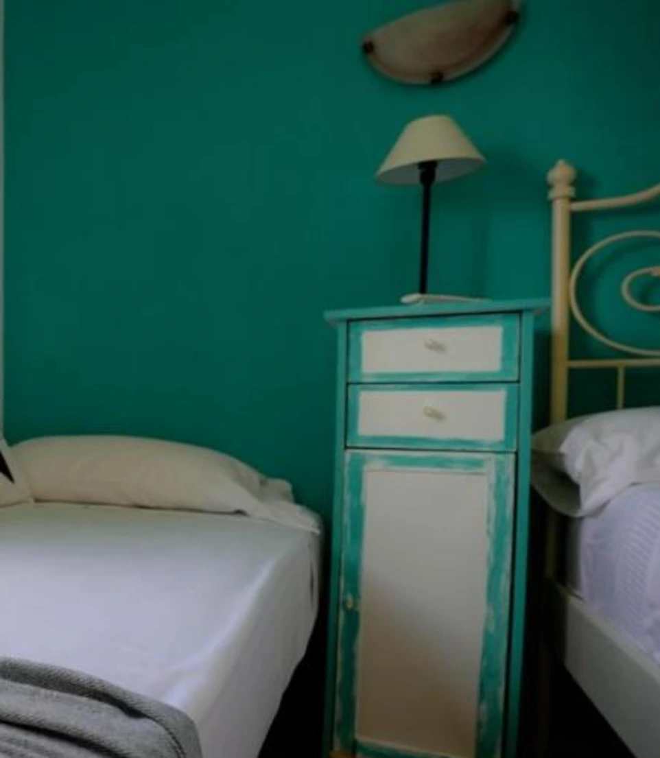 Mesa de noche con lampara al lado de una cama
