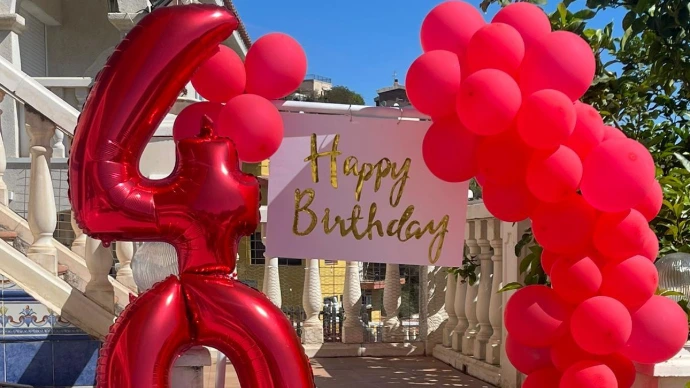 Globos rojos con cartel que dice Happy Birthday